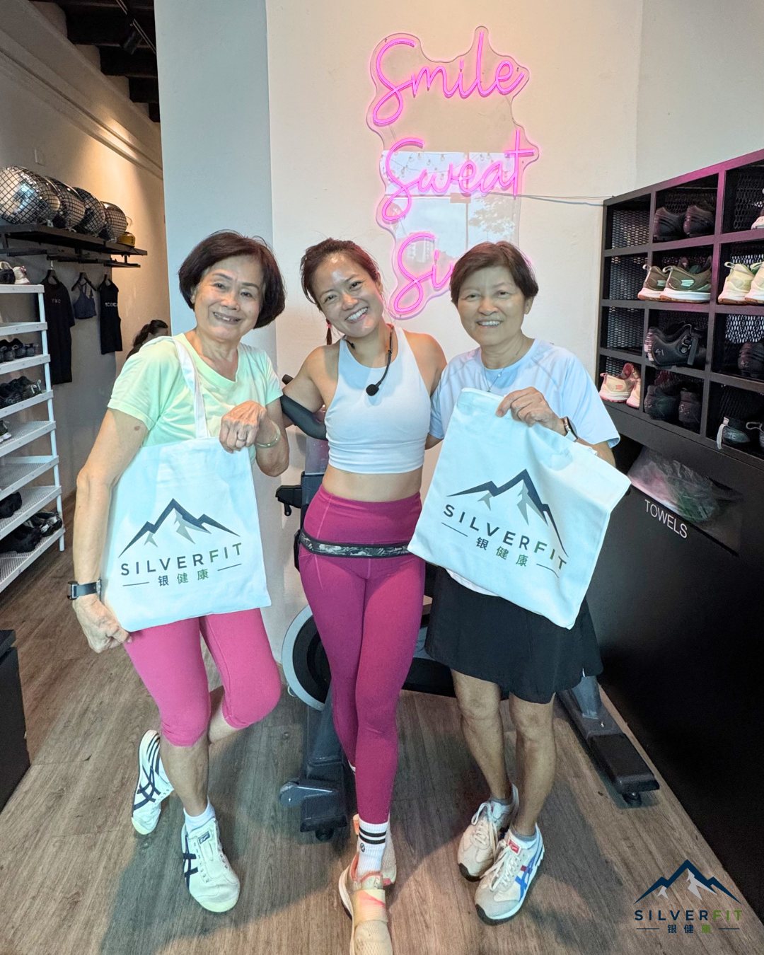 Yvonne Ong and two SilverFit seniors smiling together holding SilverFit branded tote bags