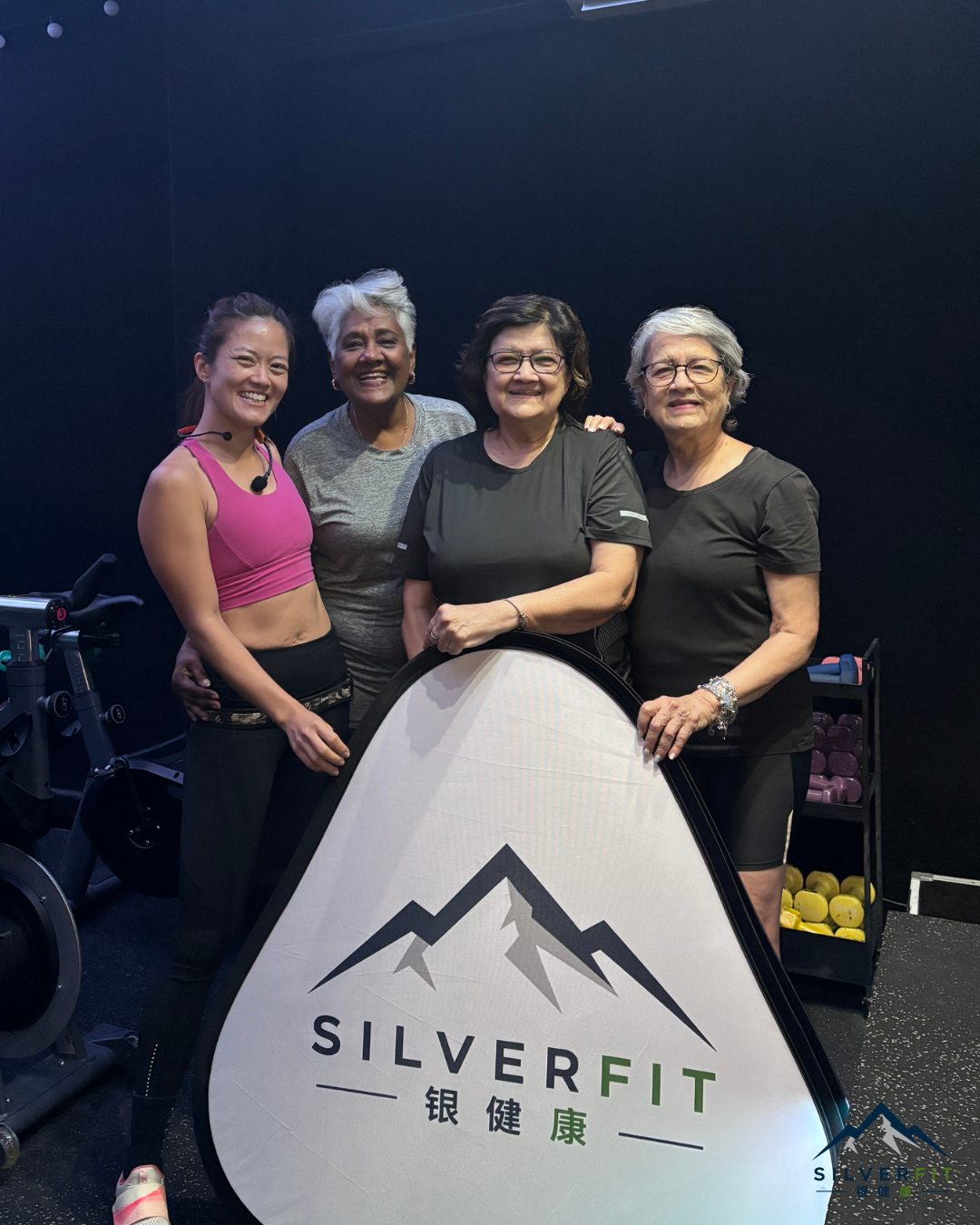 Four women from the SilverFit community smiling together at a spin session
