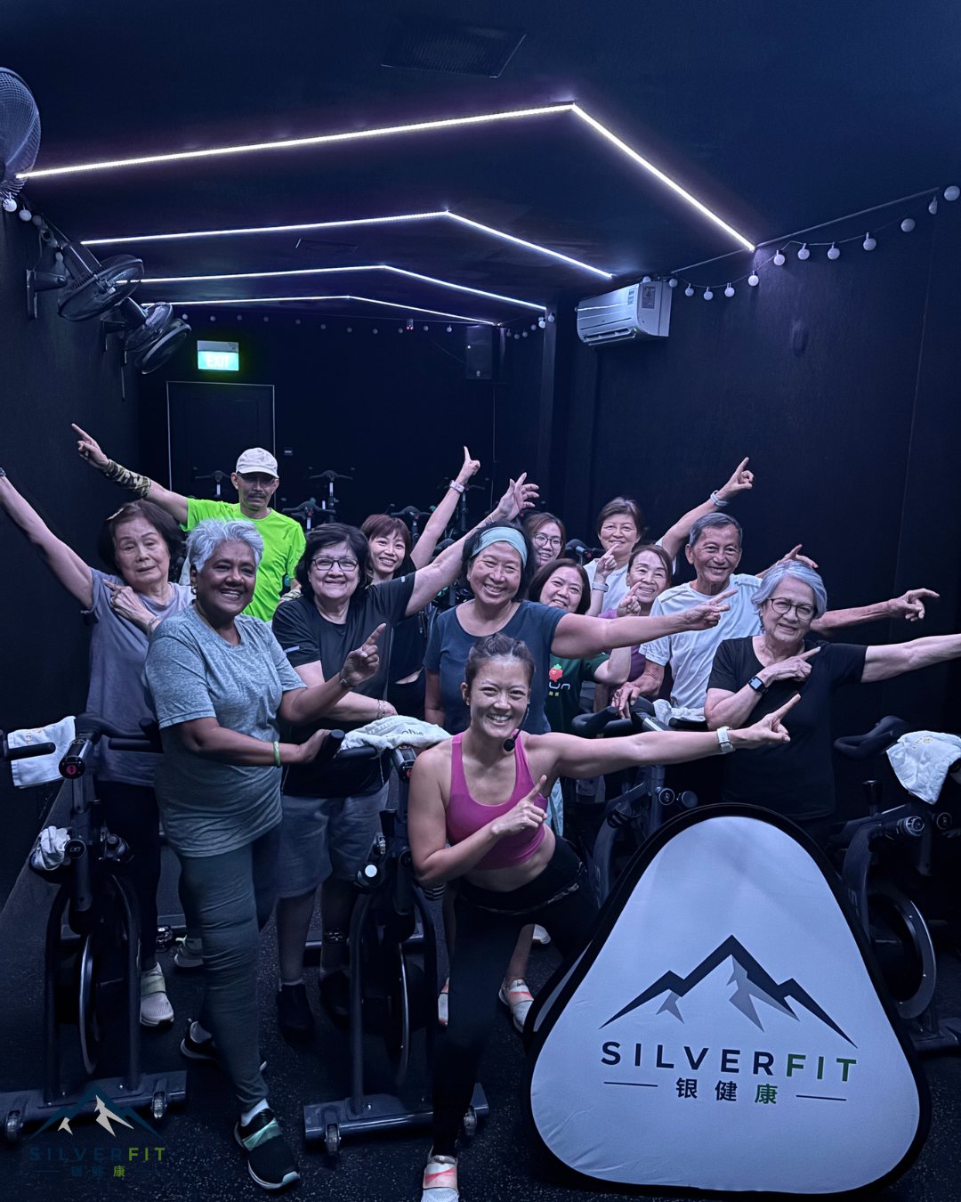 A full class of SilverFit seniors and their coach celebrating together after a group session