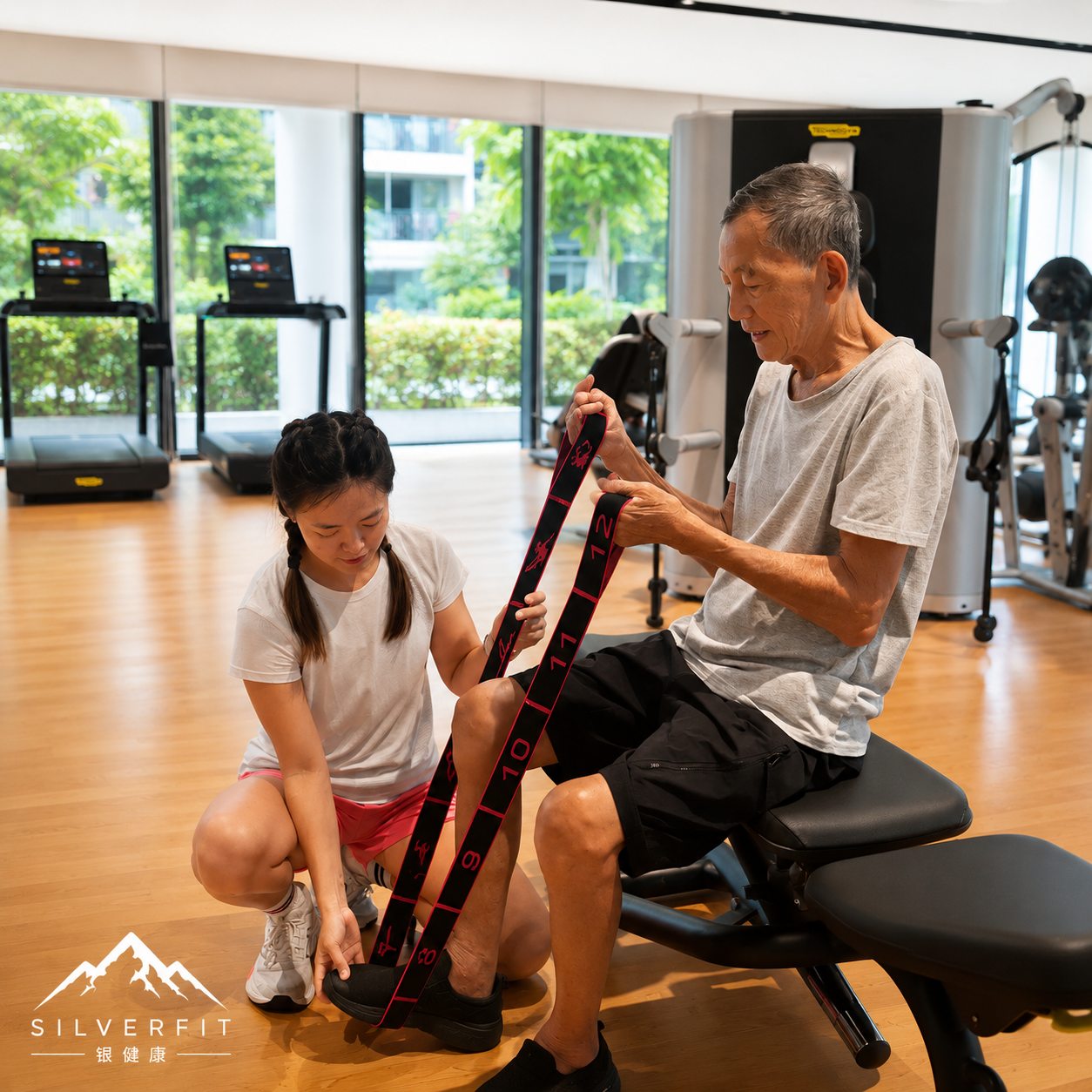 A SilverFit coach supporting a senior client during a guided stretch
